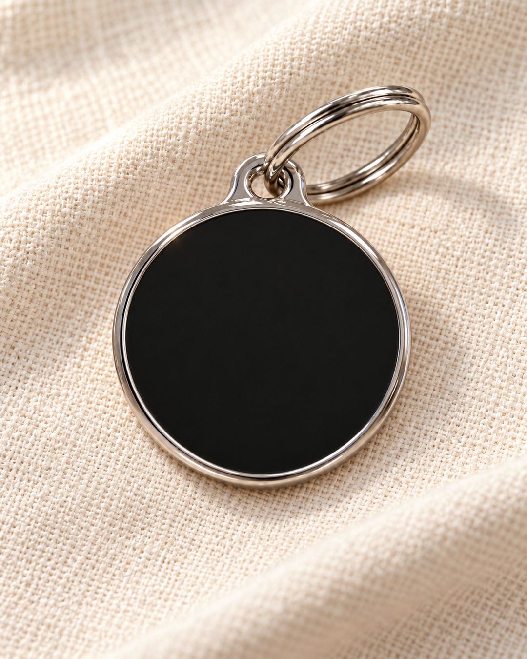 TAGiDOG Solid Round Black ID Tag dog ID tag on light linen